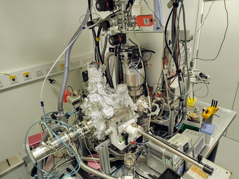 The ESIBD setup (covered by aluminium foil) and the commercial mass spectrometer Orbitrap UHMR in the back (behind the middle white panel)